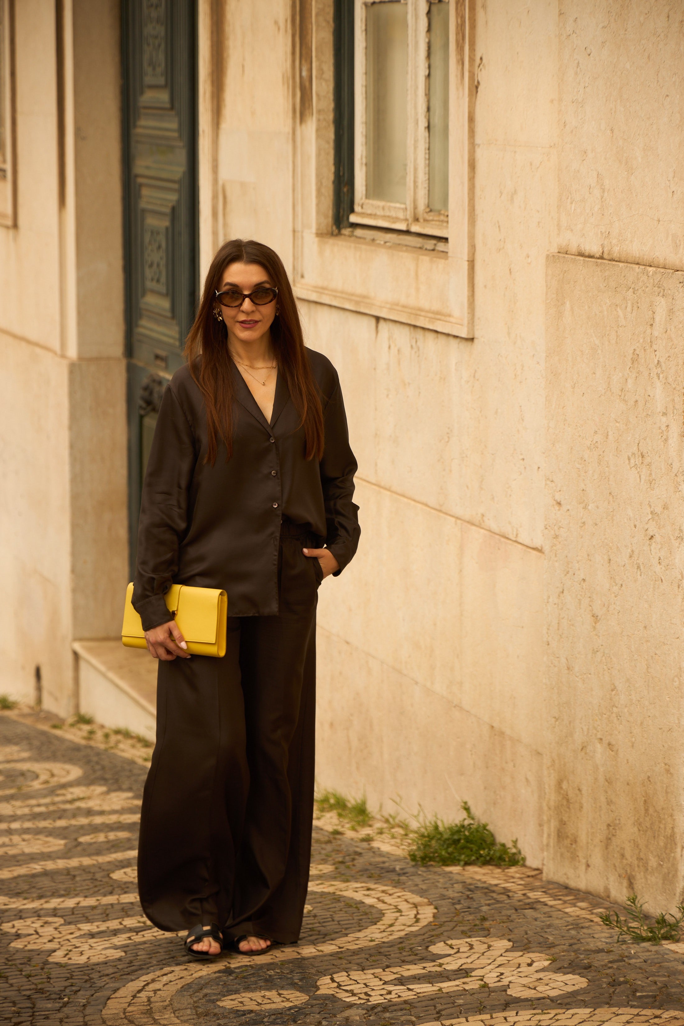 Woman in NOTTO silk set espresso brown walking the streets of Lisbon