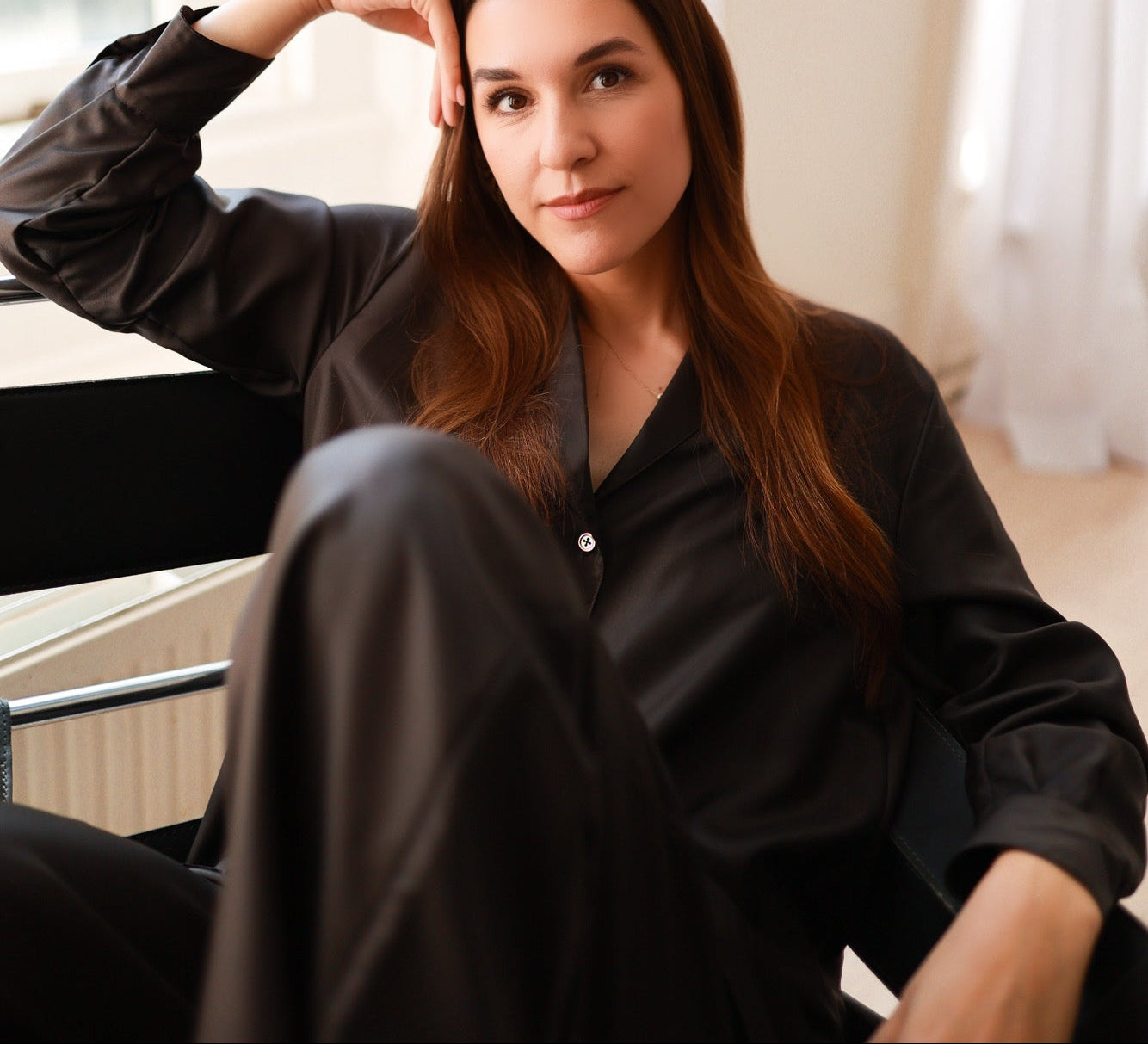 Woman sitting indoors with a neutral expression, wearing espresso brown NOTTO set