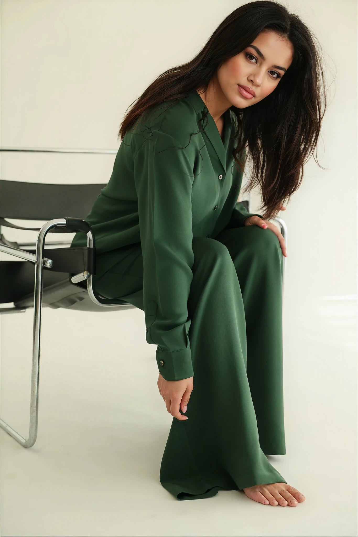 Woman sitting on a silly chair wearing full Notto set in emerald green