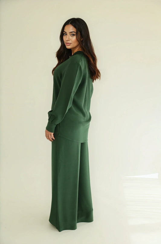 Woman standing turned to her side, wearing a full NOTTO silk set in emerald green